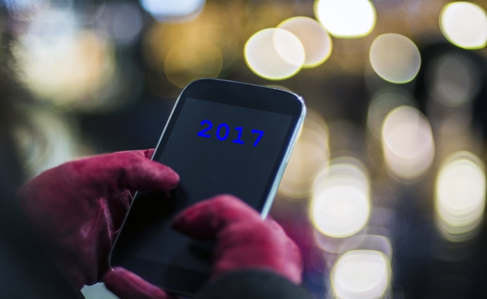 Human hands using smartphone in city at night time